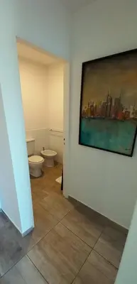 a bathroom with a toilet and a painting on the wall at Departamento Rivera in Cordoba