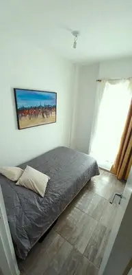 a bedroom with a bed and a painting on the wall at Departamento Rivera in Cordoba