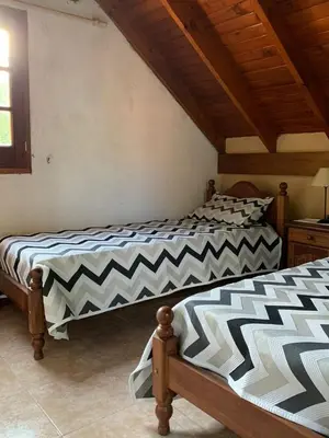 two beds sitting next to each other in a bedroom at Complejo Villa General Belgrano in Villa General Belgrano