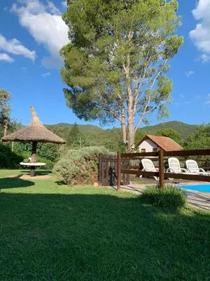 a fence with chairs and a gazebo in a yard at Complejo Villa General Belgrano in Villa General Belgrano