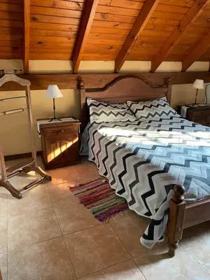 a bedroom with a bed with a wooden ceiling at Complejo Villa General Belgrano in Villa General Belgrano