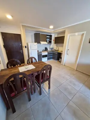 a kitchen and dining room with a wooden table and chairs at Departamento VCP Costanera in Villa Carlos Paz