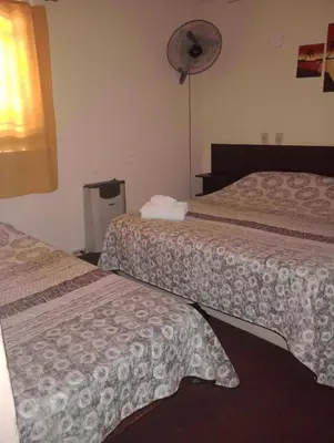 a hotel room with two beds and a fan at Hotel Las Vegas in Villa Carlos Paz