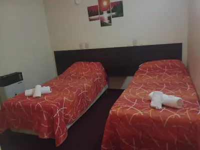two beds in a hotel room with towels on them at Hotel Las Vegas in Villa Carlos Paz