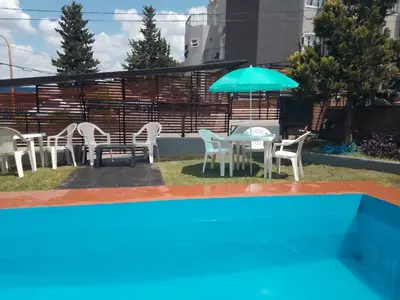 a patio with a table and chairs and an umbrella at Hotel Las Vegas in Villa Carlos Paz