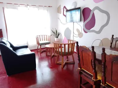 a living room with chairs and a table and a tv at Hotel Las Vegas in Villa Carlos Paz