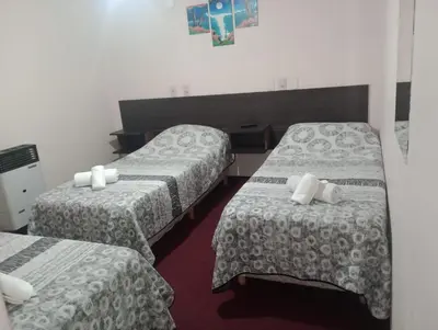 a hotel room with two beds with white sheets at Hotel Las Vegas in Villa Carlos Paz