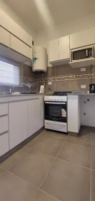 a kitchen with white cabinets and a stove top oven at Hermoso departamento a estrenar 3 in Alta Gracia