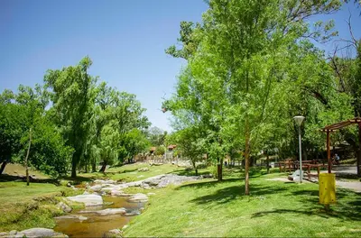 a park with a river and trees and a street light at Hermoso departamento a estrenar 3 in Alta Gracia