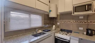 a kitchen with a sink and a stove and a microwave at Hermoso departamento a estrenar 3 in Alta Gracia