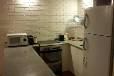a kitchen with a white refrigerator and a microwave at Dique Los Molinos Exclusiva casa vista al lago in Cordoba