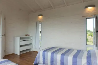 a white room with a bed and a window at Dique Los Molinos Exclusiva casa vista al lago in Cordoba