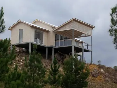 a house on top of a hill with trees at Dique Los Molinos Exclusiva casa vista al lago in Cordoba