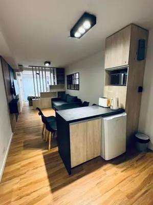 a kitchen with a counter and chairs in a room at Departamento ideal en Nueva Córdoba SS5 in Cordoba