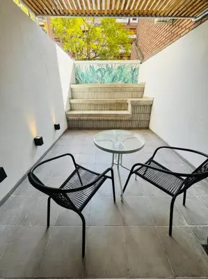 a patio with two chairs and a table and stairs at Departamento ideal en Nueva Córdoba SS5 in Cordoba