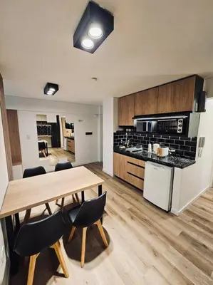 a large kitchen with a wooden table and chairs at Departamento tranquilo y luminoso en Nva Cba SS7 in Cordoba