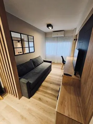 a living room with a black couch and a television at Departamento tranquilo y luminoso en Nva Cba SS7 in Cordoba