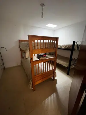 a small room with a bunk bed and a wooden chair at Apart Pilar in Pilar