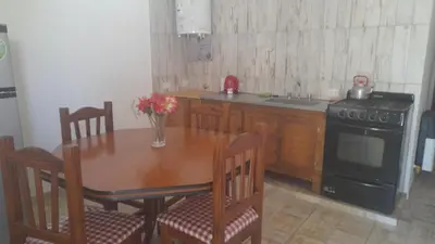 a kitchen with a wooden table and a stove at CapFer Alojamiento in Alta Gracia