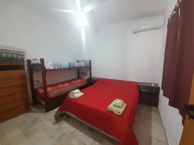 a room with a red bed with two trays on it at CapFer Alojamiento in Alta Gracia