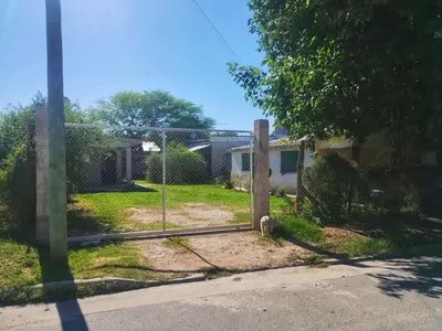 a dog in a fence in front of a house at CapFer Alojamiento in Alta Gracia