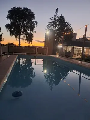 an empty swimming pool with a sunset in the background at Cabaña Alma Serrana in Bialet Massé