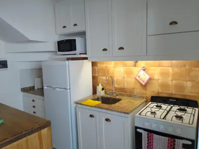 a kitchen with a stove and a white refrigerator at duplex13b in Cordoba