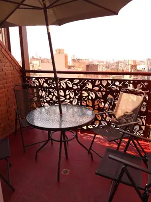 a table and chairs on a balcony with an umbrella at duplex13b in Cordoba