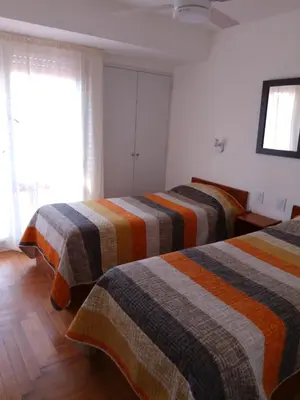 a bedroom with two beds with striped blankets at duplex13b in Cordoba