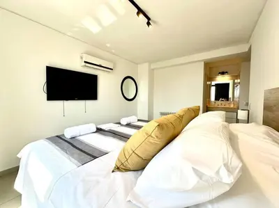 a bedroom with a large white bed and a flat screen tv at Departamento para 6 personas in Cordoba
