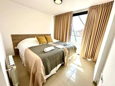 a bedroom with two beds and a large window at Departamento para 6 personas in Cordoba