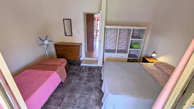 a bedroom with two beds and a dresser and a mirror at Alojamiento El Caracol in Villa Carlos Paz