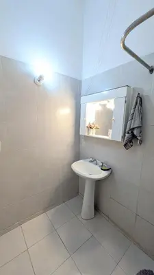 a white bathroom with a sink and a mirror at Alojamiento El Caracol in Villa Carlos Paz