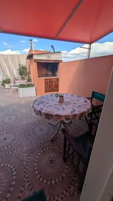 a table and chairs on a patio with a fireplace at Alojamiento El Caracol in Villa Carlos Paz