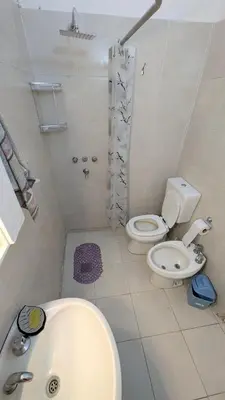 a white bathroom with a toilet and a sink at Alojamiento El Caracol in Villa Carlos Paz