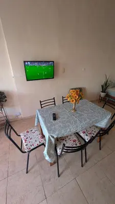 a table with two chairs and a tv on a wall at Alojamiento El Caracol in Villa Carlos Paz