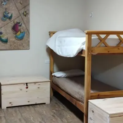 a bedroom with two bunk beds and a desk at Dormis Clave de Sol in Villa Ciudad Parque