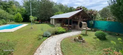 a garden with a small house and a swimming pool at CASA de Campo EL LULY in La Bolsa