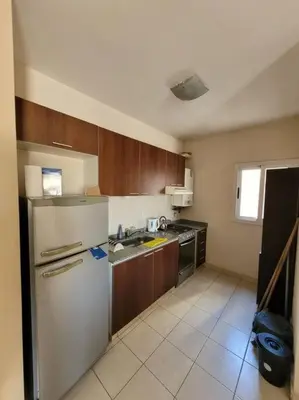 a kitchen with a white refrigerator and wooden cabinets at Departamento en Villa Carlos Paz in Villa Carlos Paz