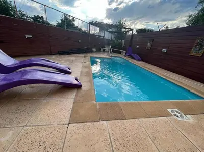 a swimming pool with a purple slide in a backyard at Departamento en Villa Carlos Paz in Villa Carlos Paz