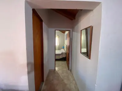 a hallway leading to a room with a bed at Departamentos Altos del Puchuqui in Santa Rosa de Calamuchita