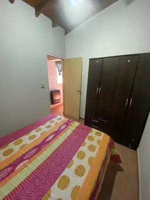 a bedroom with a bed and a dresser and cabinets at Departamentos Altos del Puchuqui in Santa Rosa de Calamuchita