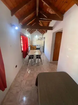 a dining room with a table and chairs in a room at Departamentos Altos del Puchuqui in Santa Rosa de Calamuchita