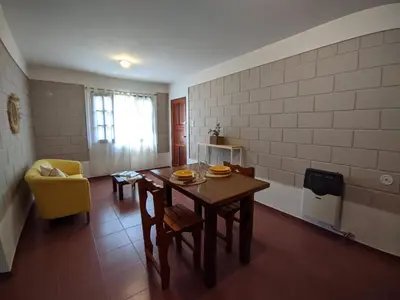 a kitchen with a table and a yellow chair at El Remanso in Villa Independencia