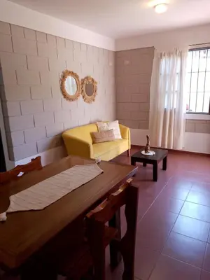 a living room with a yellow couch and a table at El Remanso in Villa Independencia