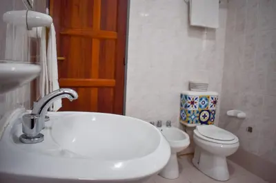 a bathroom with a white sink and a toilet at El Remanso in Villa Independencia