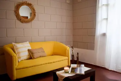 a yellow couch in a living room with a table at El Remanso in Villa Independencia