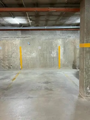 an empty parking garage with concrete walls and yellow posts at ARECAS Carlos Paz in Villa Carlos Paz
