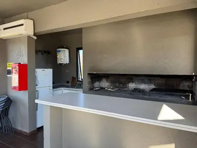 a kitchen with a counter with a fire place at ARECAS Carlos Paz in Villa Carlos Paz