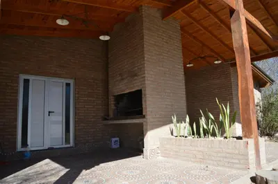 a brick house with a porch with a patio at Cabañas MACONDO in Villa Ciudad Parque